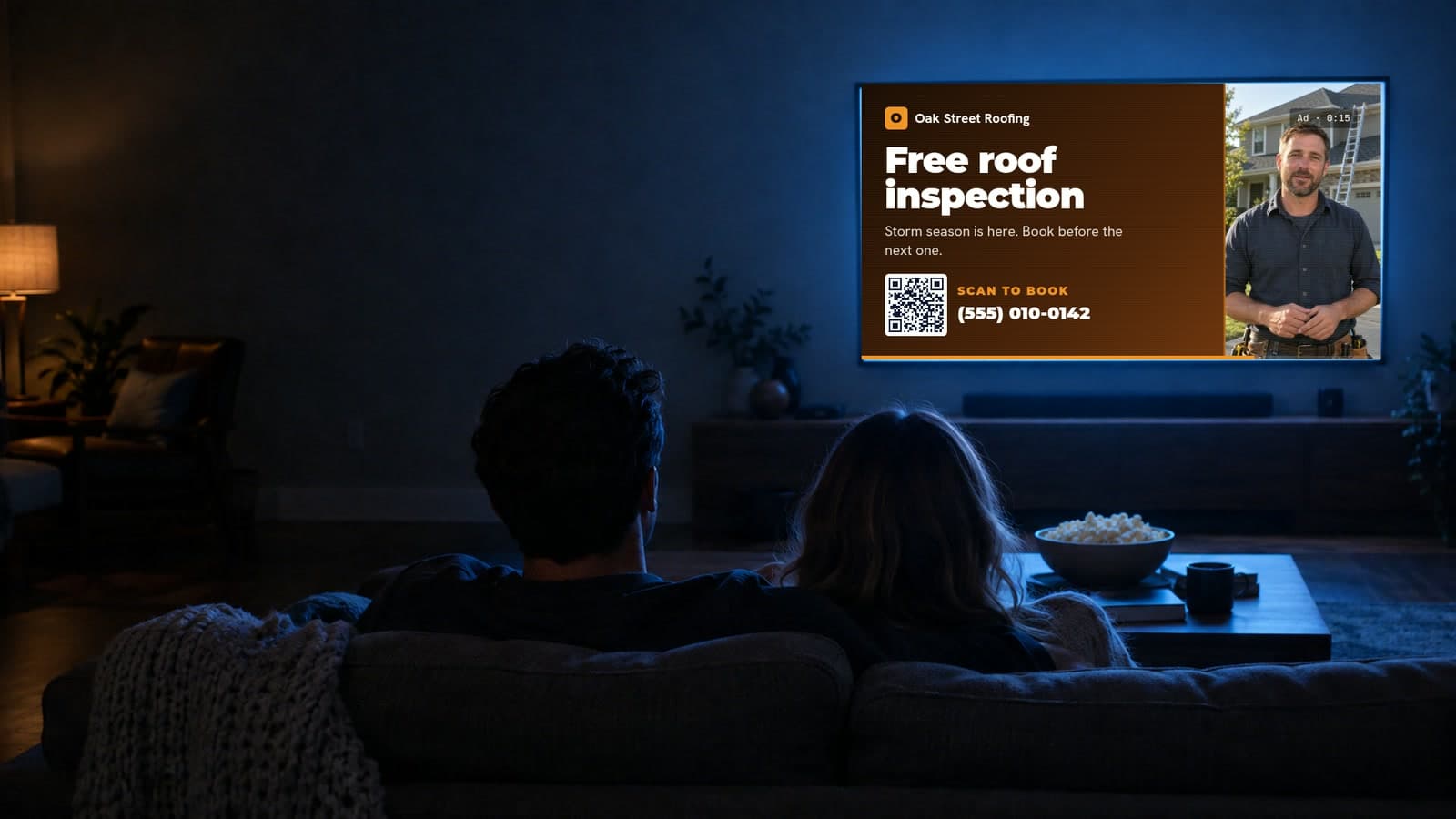 A couple on a sofa at night watching an example streaming TV ad for a roofing company: the offer and a QR code on the left, the roofer talking on the right.